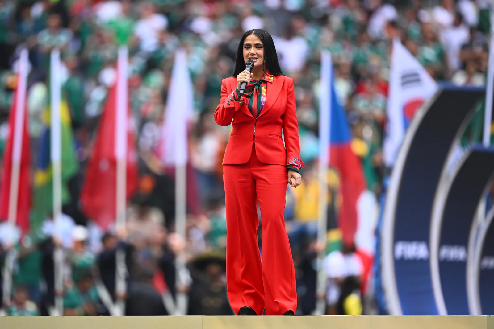 Salma Hayek deslumbra con un elegante traje rojo en una fiesta con temática futbolera.